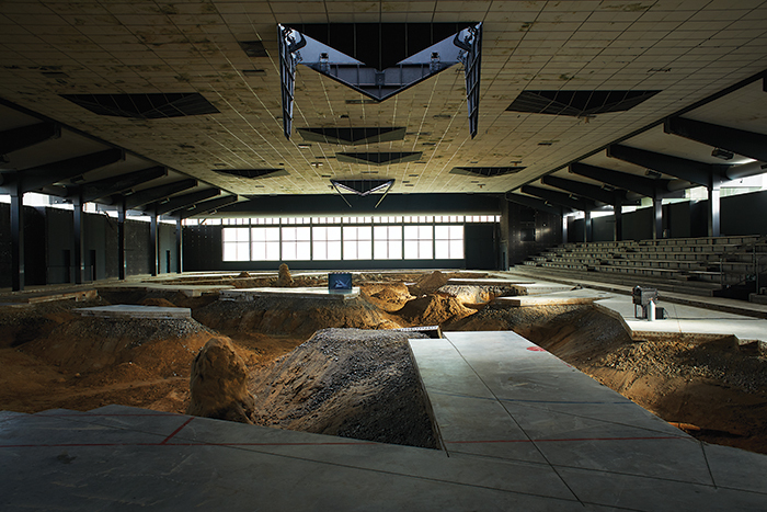Pierre Huyghe, After ALife Ahead, 2017, concrete ice-rink floor, sand, clay, phreatic water, bacteria, algae, bees, chimera peacocks, aquarium, black switchable glass, textile cone, incubator, human cancer cells, genetic algorithm, augmented-reality program, automated ceiling structure, rain, ammoniac, logic game. Installation view. From Skulptur Projekte Münster. Photo: Ola Rindal.