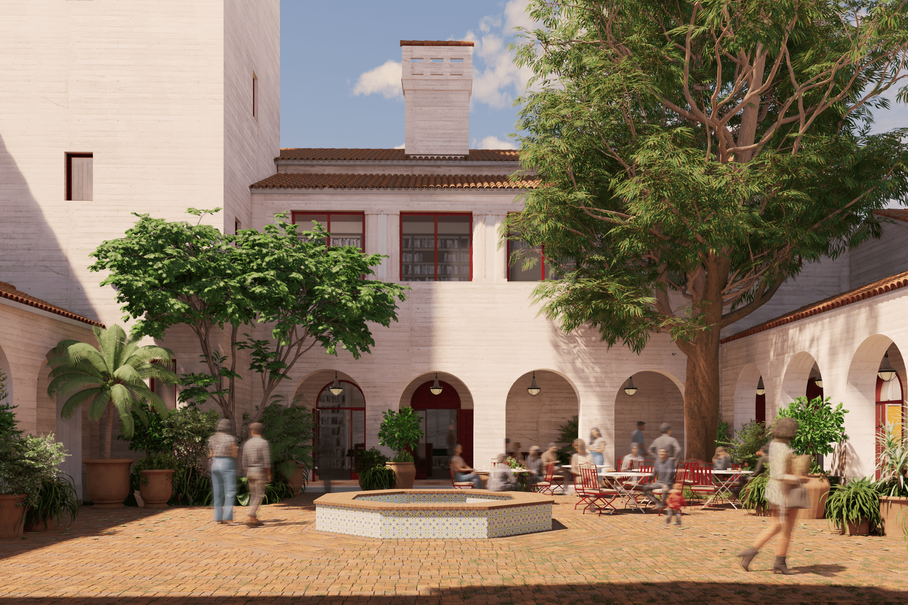 A sunny courtyard surrounded by light-colored buildings with red-tiled roofs and arched openings. The space is decorated with potted plants and trees, including a large central tree and a tiled fountain. People are walking and sitting at red tables, enjoying the calm atmosphere.